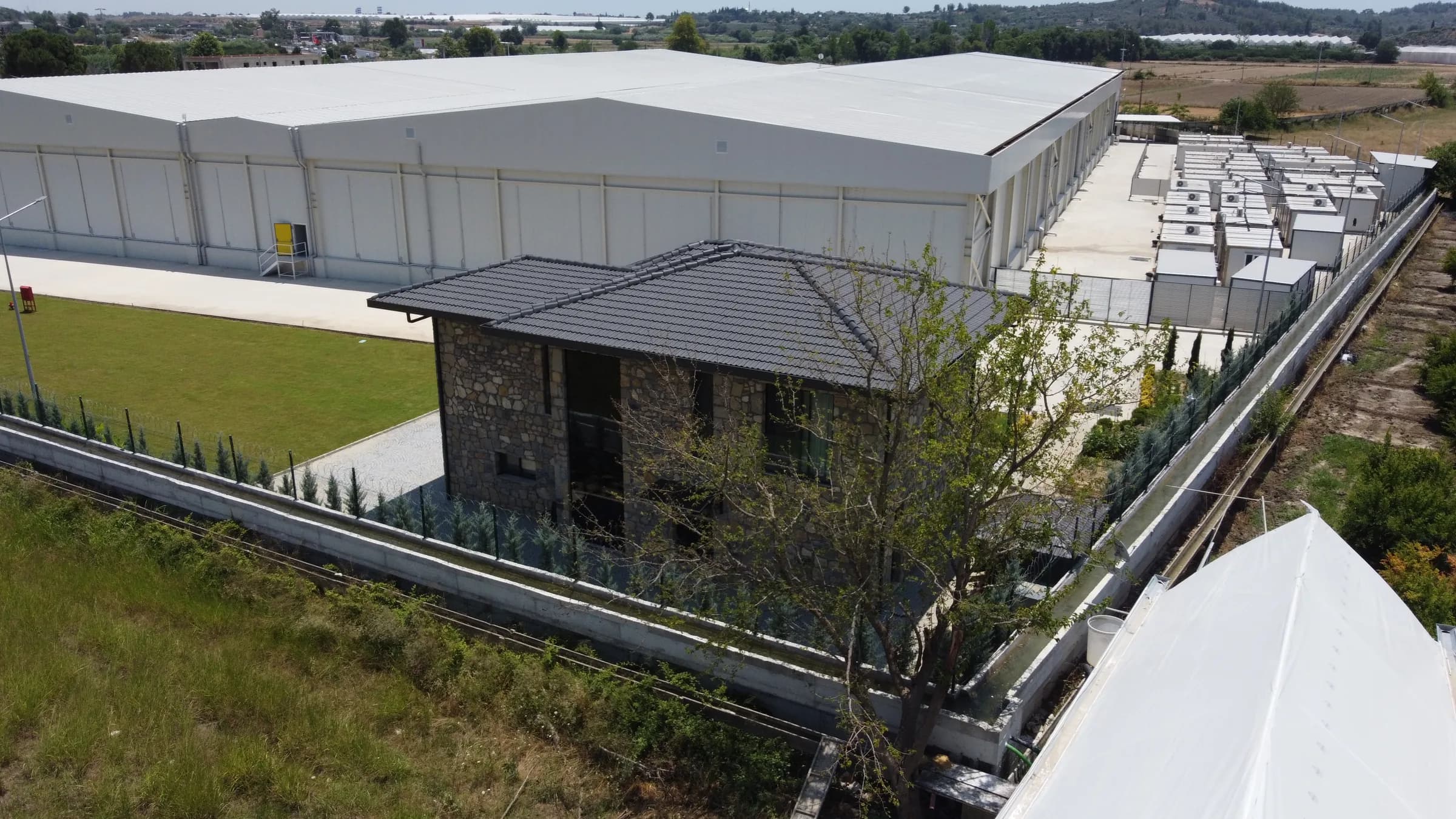 Taş villa ve çevresindeki fabrika bahçesi